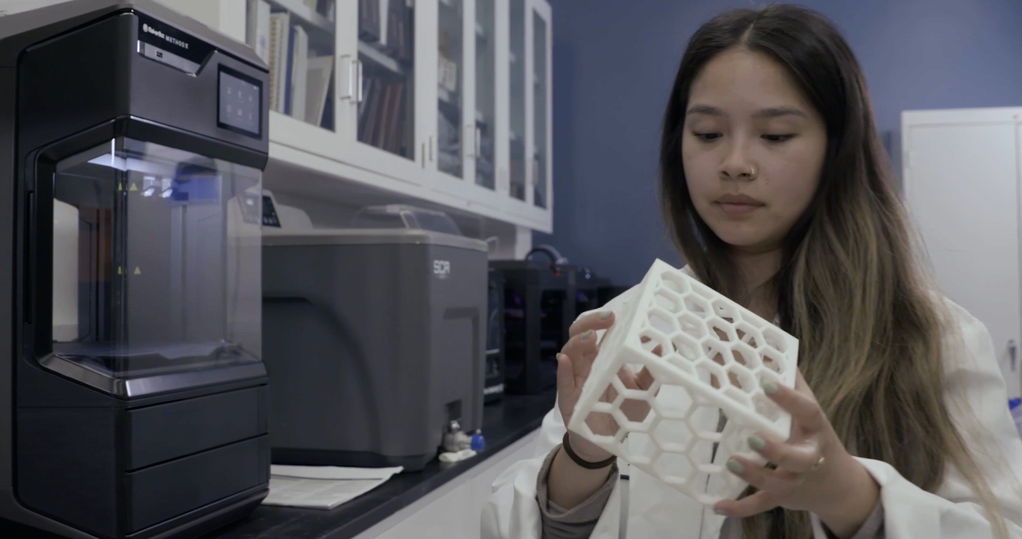 Alyssa Ruiz inspects a 3D printed electronics housing printed on METHOD X in the ATC's 3D printing lab.