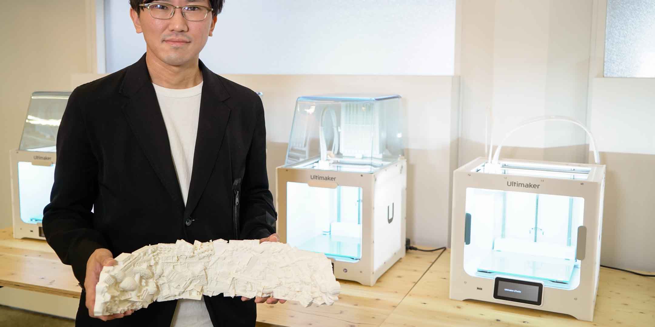 Toshiki Hirano holding a 3D printed architectural model